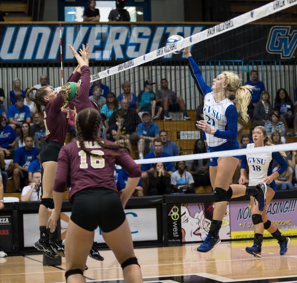 GVL/Kevin Sielaff - Staci Brower (21) spikes the ball. The Lakers sweep the Cavaliers of Walsh University Saturday, Sept. 24, 2016 in Allendale.