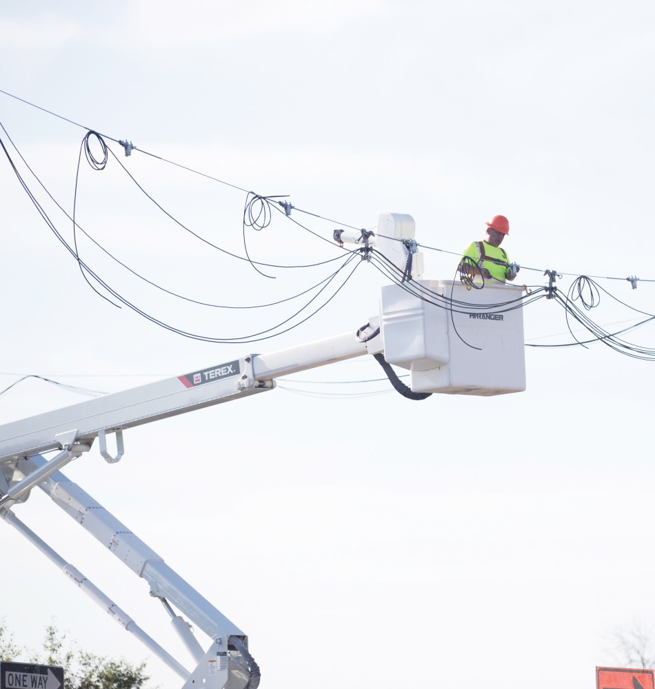 GVL/Kevin Sielaff - Strain Electric crews install overhead wiring at the intersection of West Campus Drive and 48th Ave. Thursday, August 18, 2016.