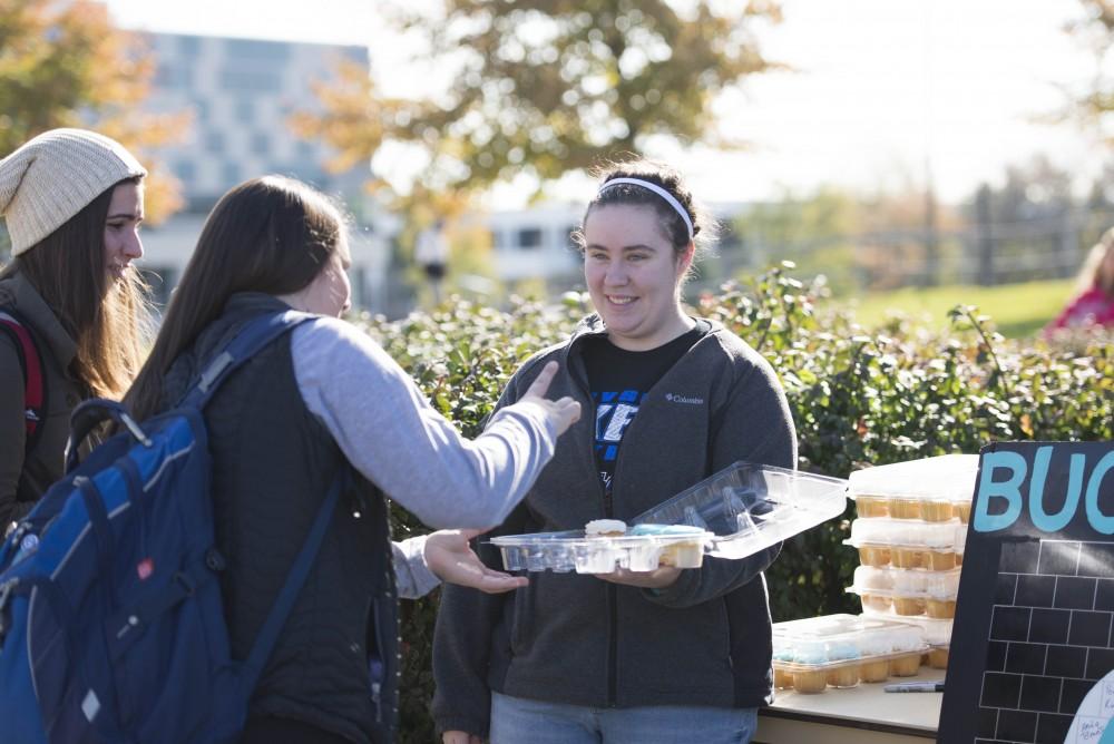 GVL / Luke Holmes - Kimberly Long passes out cupcakes. GVSU Founders Day was celebrated on Tuesday, Oct. 25, 2016 next to the clock tower.