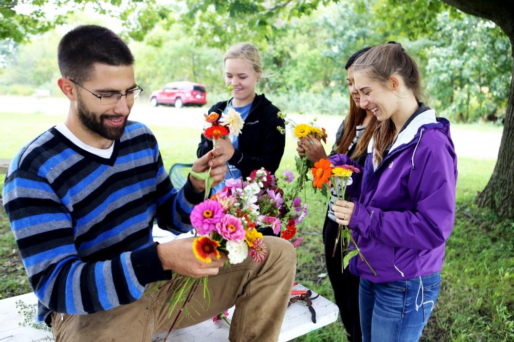 GVL / Emily Frye    
Youssef Darwich (far left) assists some Grand Valley student volunteers at the GVSU Sustainability Farm on Friday Sept. 30, 2016.