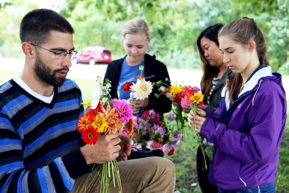 GVL / Emily Frye    
Youssef Darwich (far left) assists some Grand Valley student volunteers at the GVSU Sustainability Farm on Friday Sept. 30, 2016.