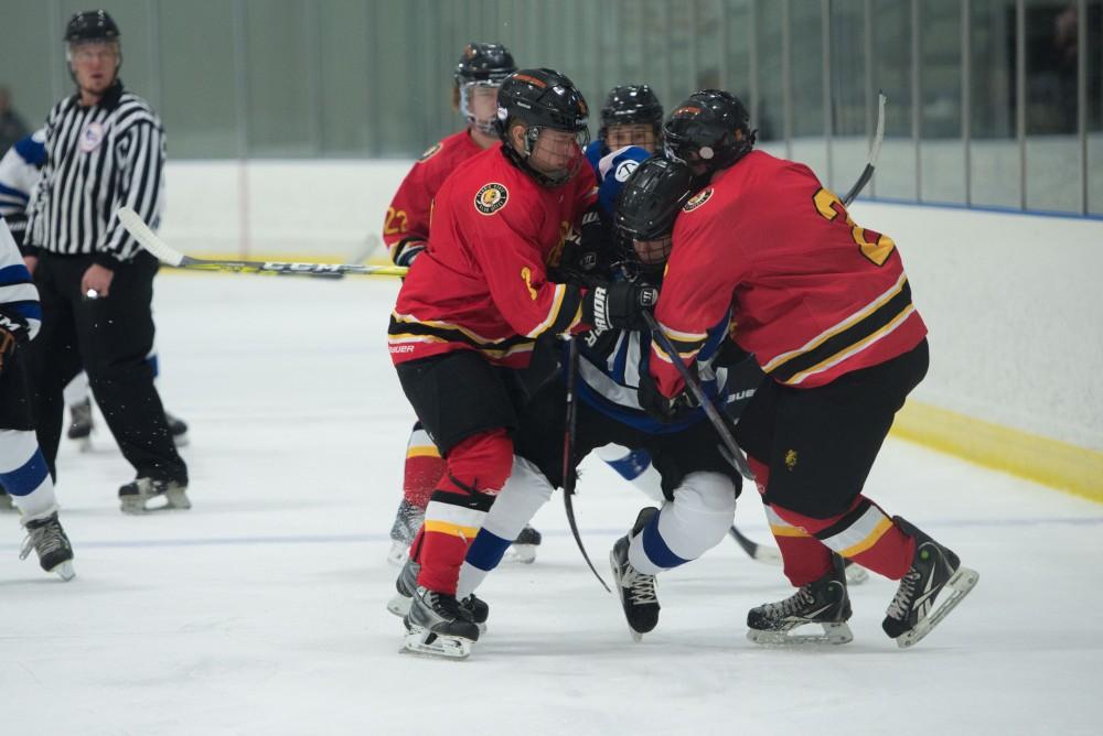 GVL / Luke Holmes - A GVSU player gets sandwiched by two defenders. GVSU Men’s D2 Hockey defeated Ferris State University with a score of 8-1 on Saturday, Oct. 16, 2016.