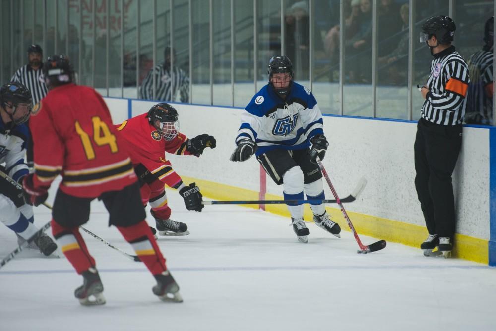 GVL / Luke Holmes - Reede Burnett (12) skates around the defender. GVSU Men’s D2 Hockey defeated Ferris State University with a score of 8-1 on Saturday, Oct. 16, 2016.