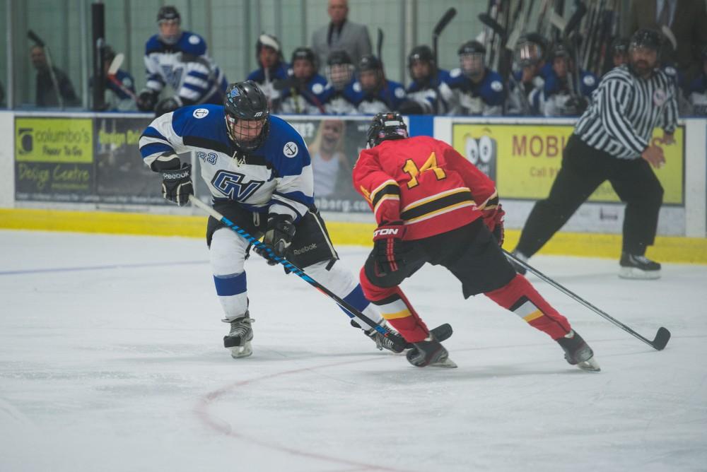 GVL / Luke Holmes - Alex Ostrowski (23) moves the puck around the defender. GVSU Men’s D2 Hockey defeated Ferris State University with a score of 8-1 on Saturday, Oct. 16, 2016.