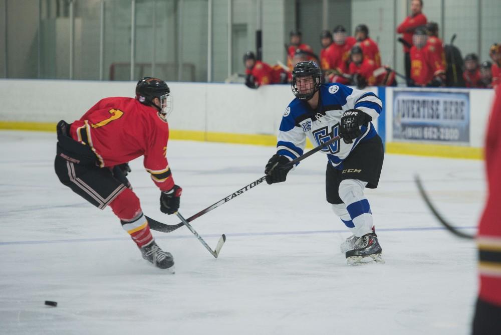 GVL / Luke Holmes - Zac Goodrich (16) passes the puck right through the defender. GVSU Men’s D2 Hockey defeated Ferris State University with a score of 8-1 on Saturday, Oct. 16, 2016.