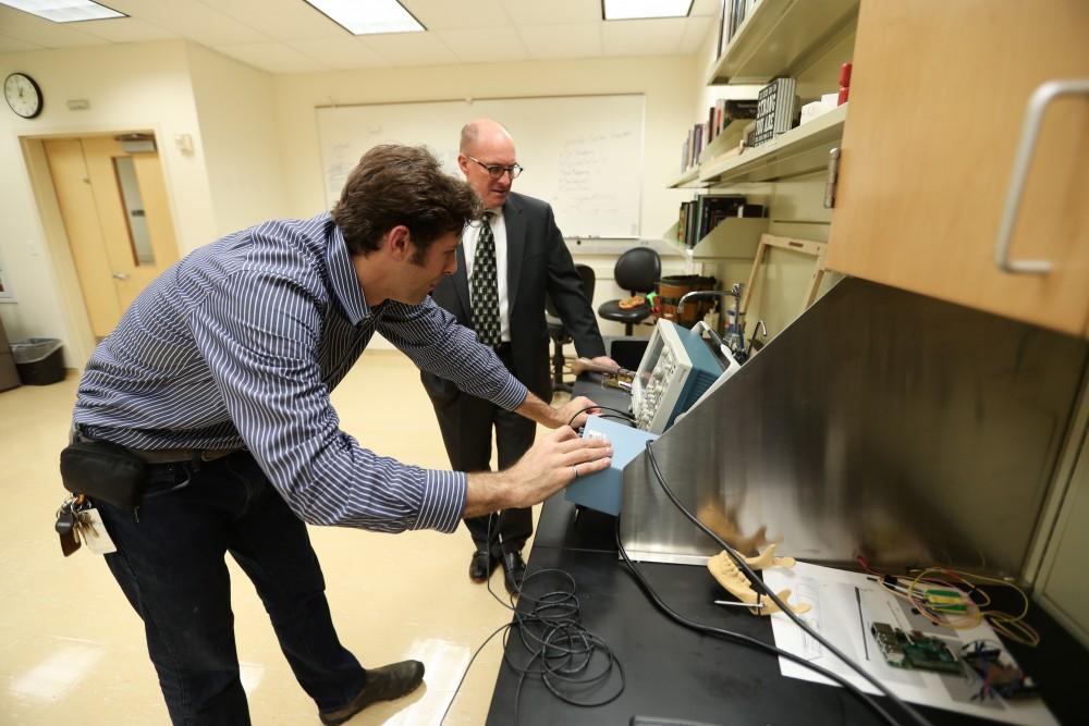 GVL/Kevin Sielaff - Members of the aMDI team Kevin Weaver (right) and Brent Nowak (left) demonstrate an orthoforge device inside of the Cook-DeVos Center for Health Sciences Wednesday, Oct. 26, 2016.  