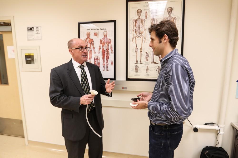 GVL/Kevin Sielaff - Members of the aMDI team Kevin Weaver (right) and Brent Nowak (left) demonstrate an external catheter device that is used to prevent UTI's inside of the Cook-DeVos Center for Health Sciences Wednesday, Oct. 26, 2016.  