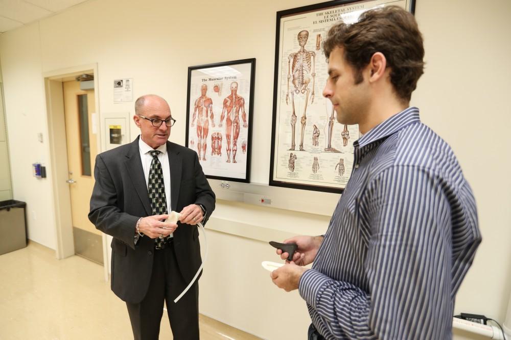 GVL/Kevin Sielaff - Members of the aMDI team Kevin Weaver (right) and Brent Nowak (left) demonstrate an external catheter device that is used to prevent UTI's inside of the Cook-DeVos Center for Health Sciences Wednesday, Oct. 26, 2016.  