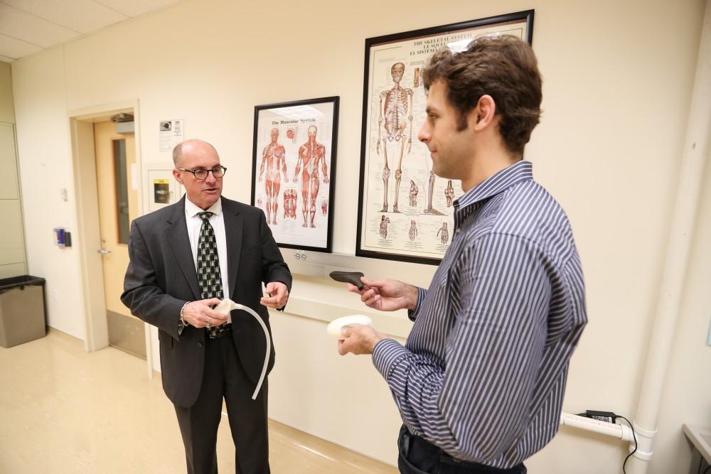 GVL/Kevin Sielaff - Members of the aMDI team Kevin Weaver (right) and Brent Nowak (left) demonstrate an external catheter device that is used to prevent UTI's inside of the Cook-DeVos Center for Health Sciences Wednesday, Oct. 26, 2016.  