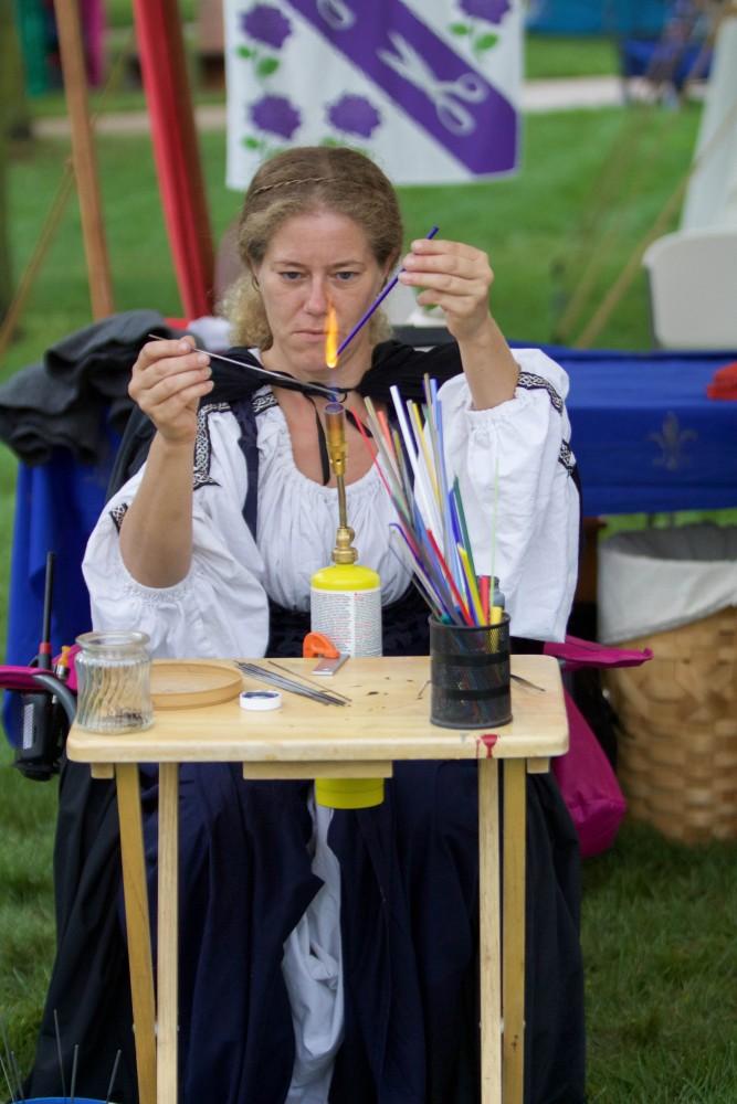GVL/Mackenzie Bush - Ezzy Ronda melts rods of glass to make beads at the Renaissance Fstival on Saturday, Oct. 1, 2016 outside of Kirkof.