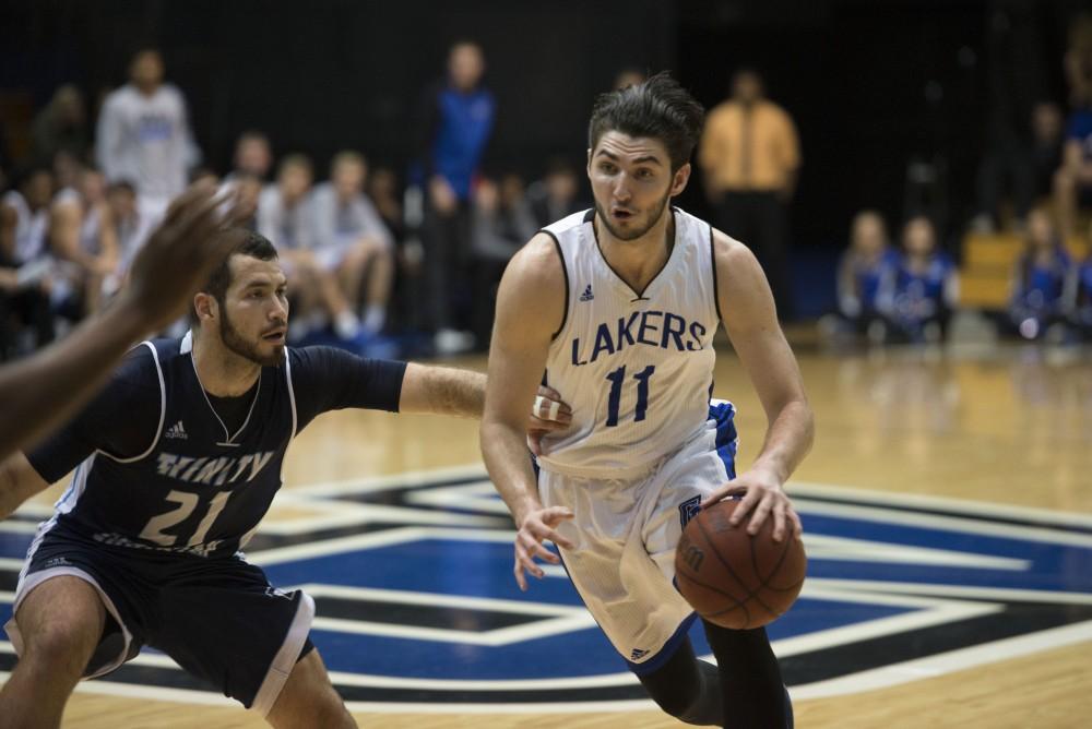 GVL / Luke Holmes - Zach West (11) dribbles around a defender. GVSU defeated Trinity Christian on Friday, Nov. 18, 2016. 