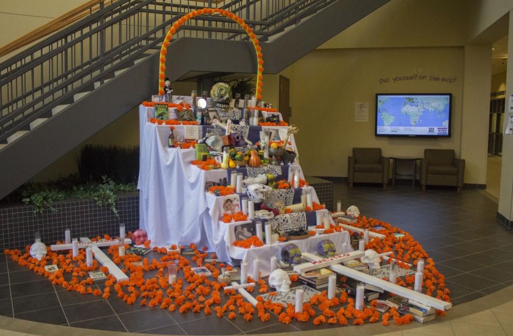 GVL/Mackenzie Bush - GVSU students celebrate Day of the Dead with LAS, Latin American, and Latino Studies by placing pictures of loved ones on an alter. The alter, built by artist Roli Mancera, was set up in Neimeyer the week of Nov. 1, 2016.