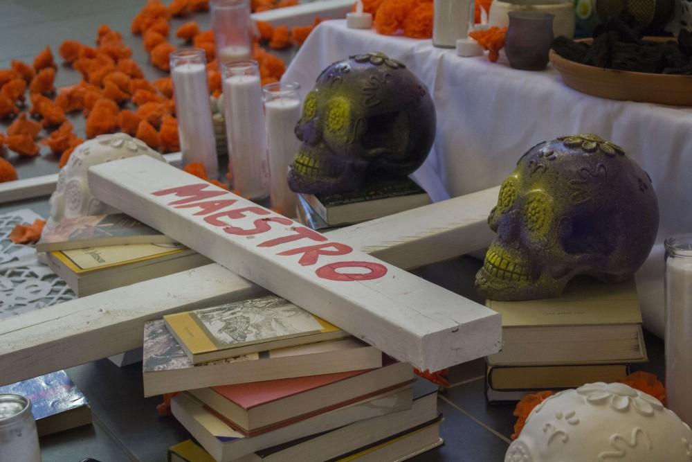 GVL/Mackenzie Bush - GVSU students celebrate Day of the Dead with LAS, Latin American, and Latino Studies by placing pictures of loved ones on an alter. The alter, built by artist Roli Mancera, was set up in Neimeyer the week of Nov. 1, 2016.