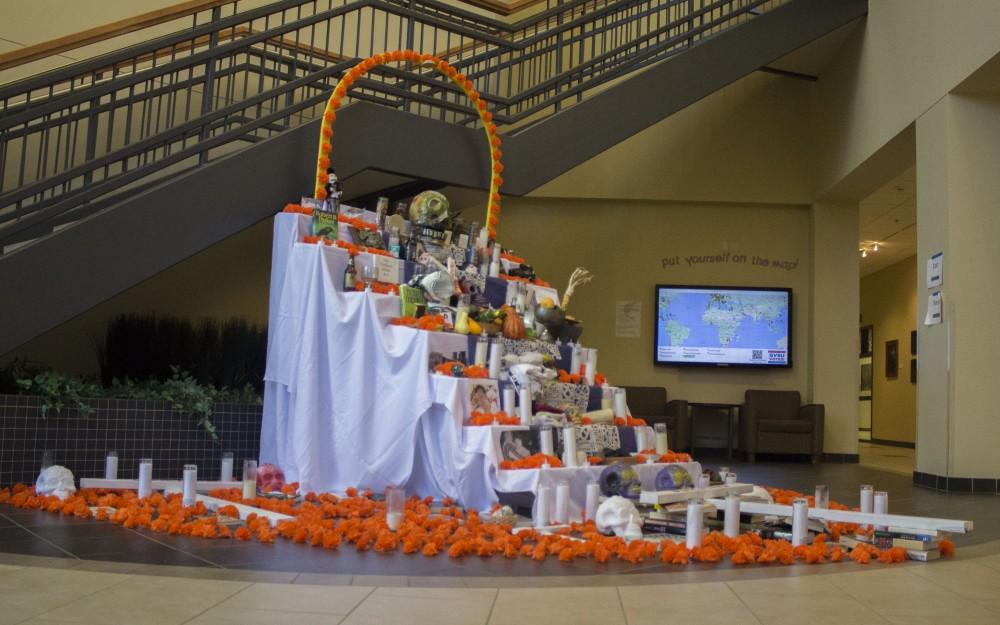 GVL/Mackenzie Bush - GVSU students celebrate Day of the Dead with LAS, Latin American, and Latino Studies by placing pictures of loved ones on an alter. The alter, built by artist Roli Mancera, was set up in Neimeyer the week of Nov. 1, 2016.