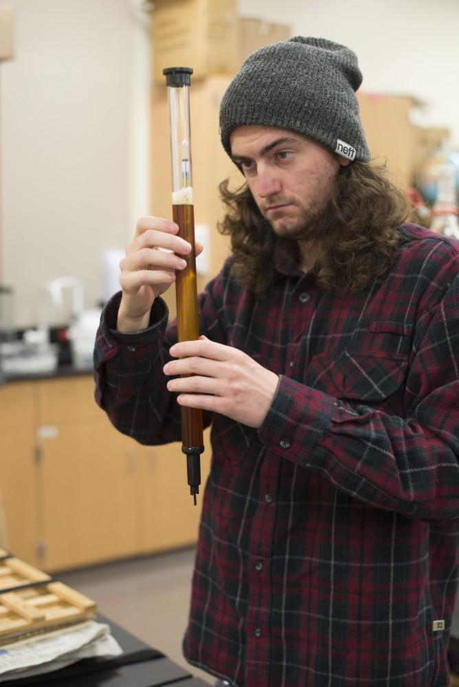 GVL / Luke Holmes - Kyle Anderson performs a test on his beer. Biology professor, Mark Staves, teaches the CMB 350 Foundations of Brewing course. 