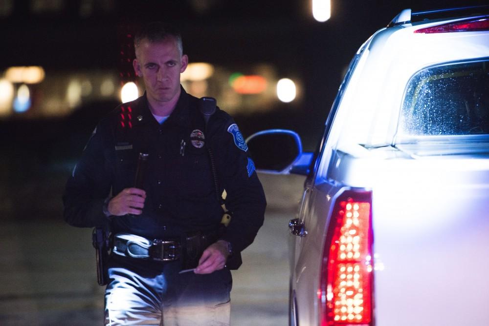 GVL / Luke Holmes - Sergeant Stoll returns to his car after making a traffic stop. The ride along with Sergeant Jeff Stoll took place on Saturday, Oct. 29, 2016.