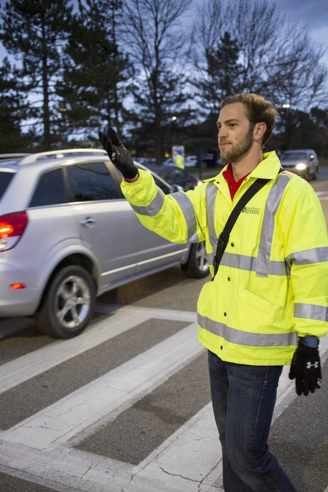 GVL / Sara Carte 
Cross walk attendant, Alex Putkovich, guides traffic on Grand Valley’s Allendale Campus on Tuesday, Nov. 8, 2016.