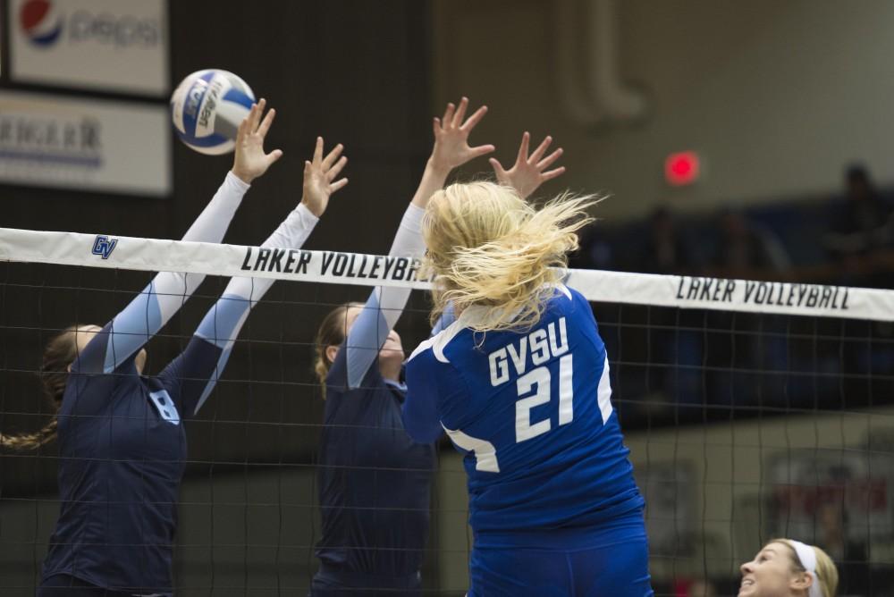 GVL / Luke Holmes - Staci Brower (21) spikes the ball past the blockers. GVSU volleyball defeated Northwood in three games in the Fieldhouse Arena on Friday, Nov. 11, 2016.