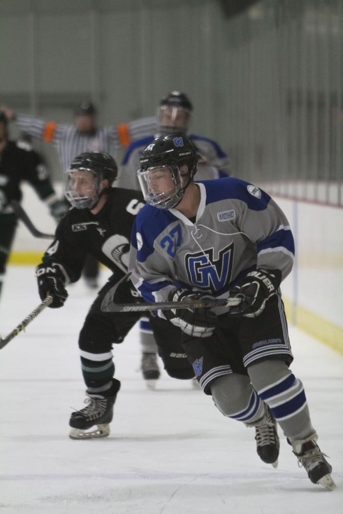 GVL/Mackenzie Bush - Corey Smith (27) races to intercept the puck. GVSU Men’s D3 Hockey plays Michigan State University Saturday, Dec. 10, 2016. 