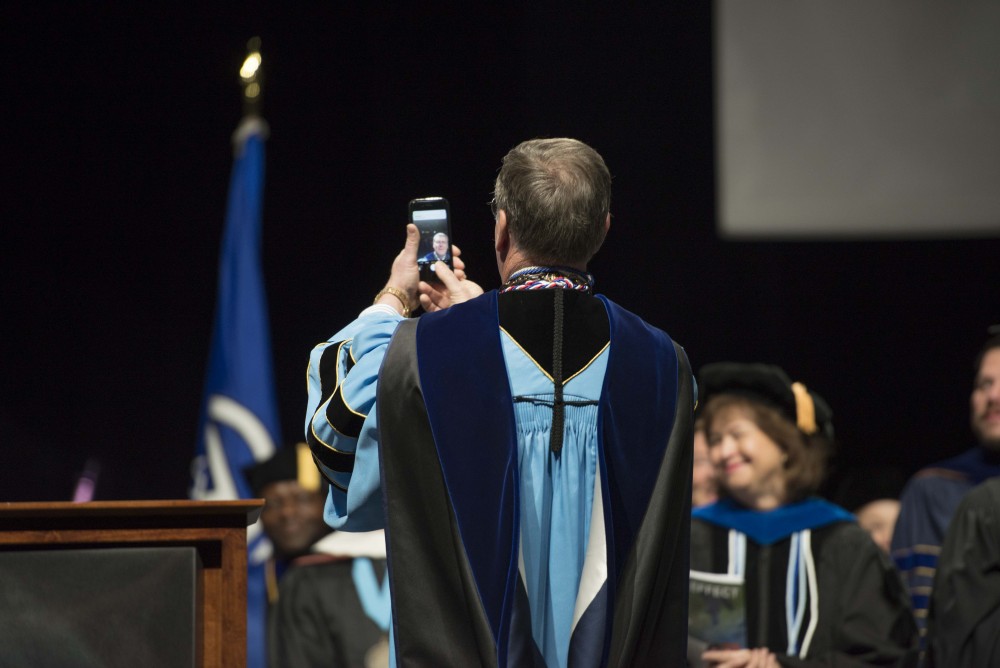 GVL / Luke Holmes - T. Haas takes a selfie before starting his speech. GVSU commencement was held in Van Andel Arena on Saturday, Dec. 10, 2016.