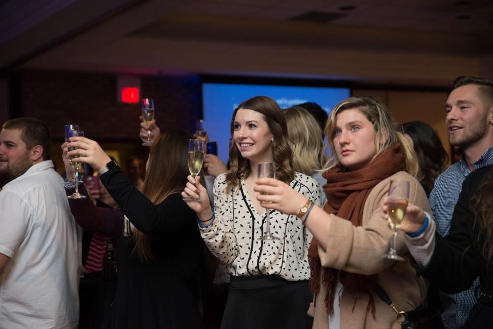 GVL / Luke Holmes -Students raise a glass to graduating. Students celebrate a "Toast with T. Haas" in the Eberhard Center on Thursday, Dec. 8, 2016.