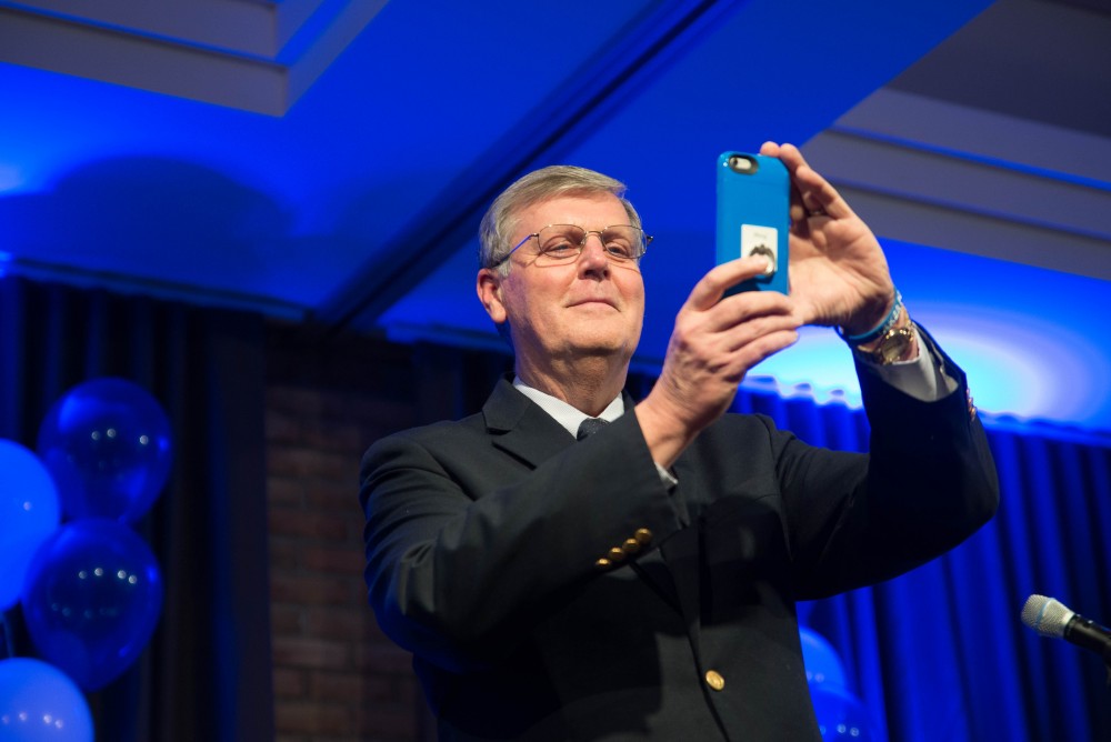 GVL / Luke Holmes - President T. Haas takes a video with his phone before giving his speech. Students celebrate a "Toast with T. Haas" in the Eberhard Center on Thursday, Dec. 8, 2016.