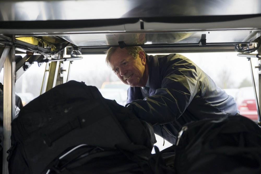 GVL / Luke Holmes - The bus driver loads some luggage into the bottom of the bus before taking off.