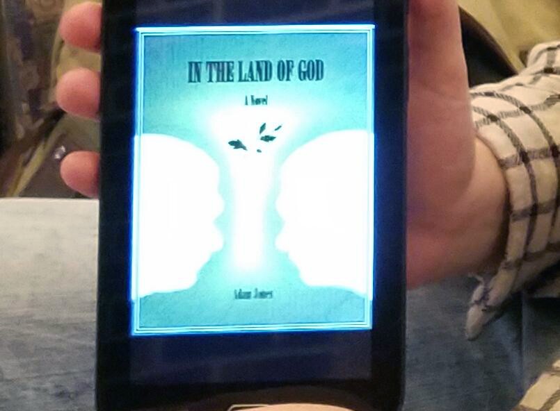 GVL/Christa Wright - Adam Jones holds his book In the Land of God on Wednesday, Jan. 25, 2017 inside Grand Valleys Kirkhof Center.