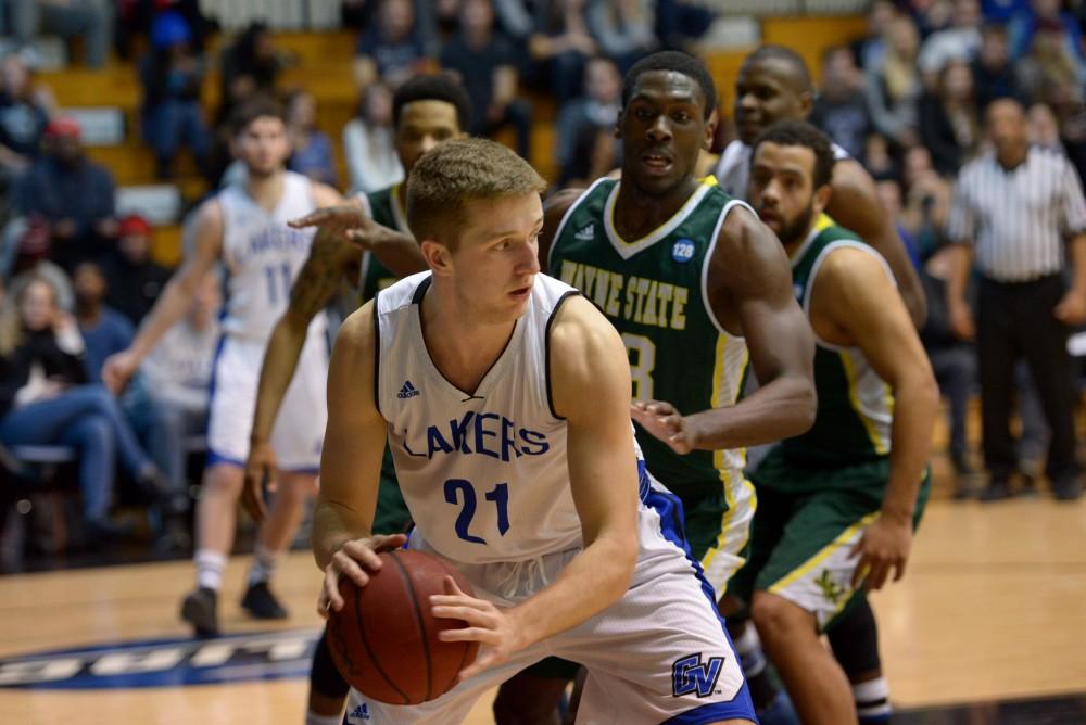 GVL / Luke Holmes - Drake Baar (21) protects the ball from the defender. GVSU men’s basketball defeated Wayne State University on Thursday, Jan.19, 2017.