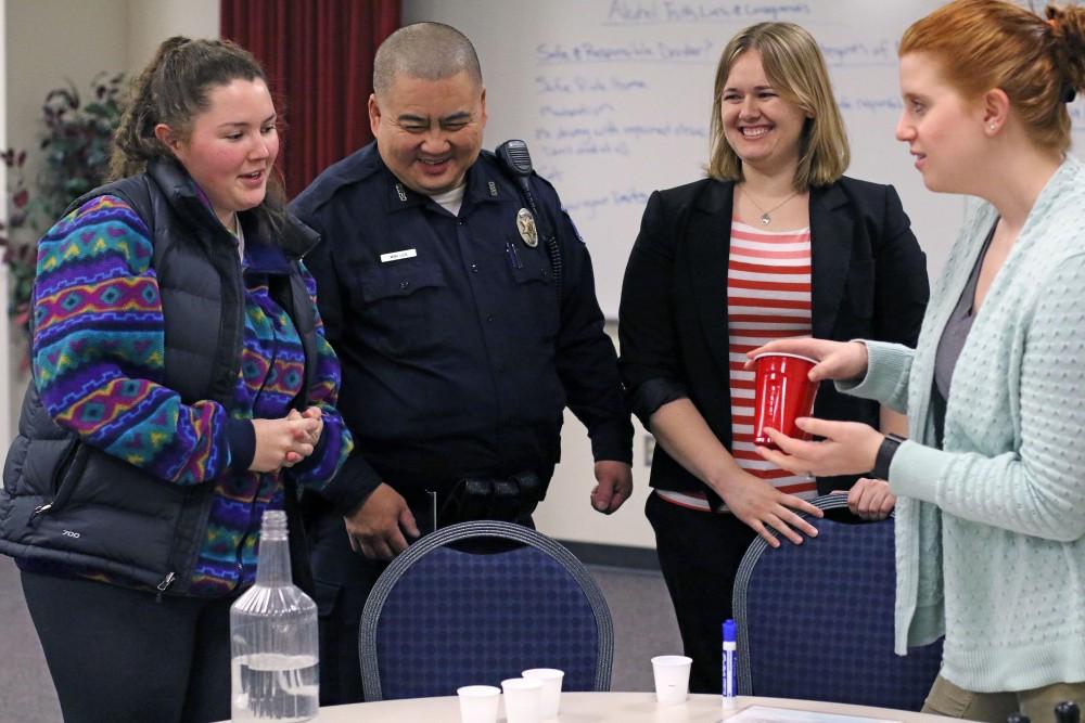 GVL / Emily Frye      Shelby Simpson assists Officer Minh Lien, Katrina Rast, and Genevieve Steffes with an alcohol demonstration for ACES on Wednesday Jan. 25, 2016.