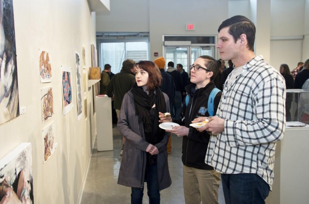 GVL / Courtesy - GVSU University CommunicationsLauren Kohler (middle) and Sam Adamczyk (right) observe the 5th Annual Juried Art Show inside of the Calder Art Center.
