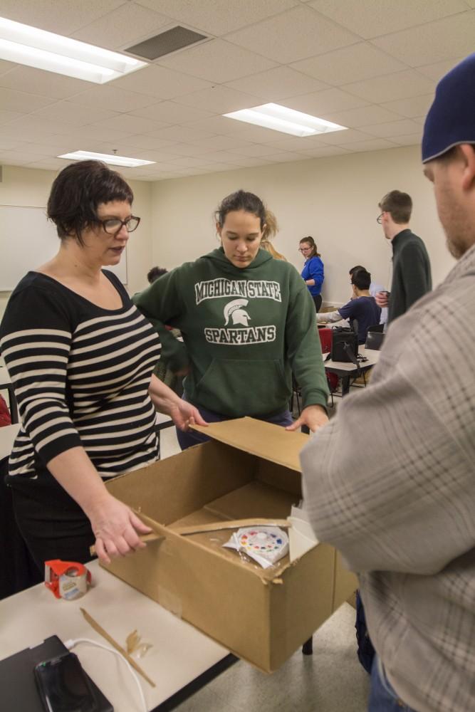 GVL/Mackenzie Bush - Kelly Roach (left) and Molly Marciszewski (right) work on their board game for the upcoming GVSU WInter Cardboard Challenge Friday, Feb. 17, 2017 in Mackinaw Hall.