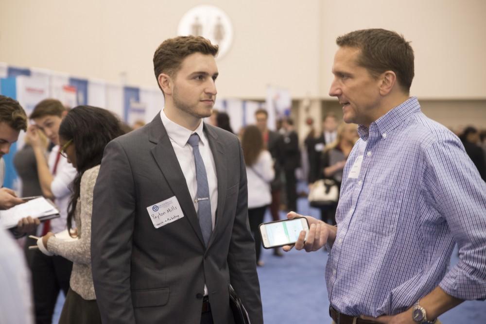 GVL / Luke Holmes - Payton Mills talks to a potential employer. The Career Fair was held in the DeVos Place on Thursday, Feb. 23, 2016.