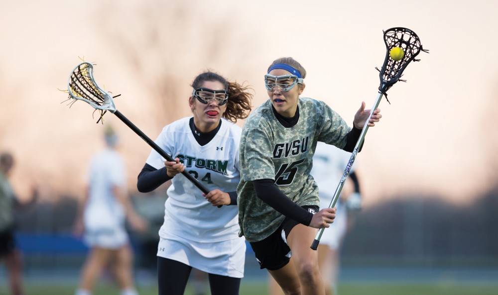 GVL / Kevin Sielaff - Meggan Loyd (15) tries a shot on net and scores. Grand Valley defeats Lake Erie College with a final score of 19-2 on Friday, April 29, 2016 in Allendale. 