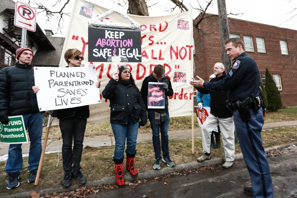 Grand Rapids Police Department's officer Brad Bush controls the crowd in front of the Planned Parenthood building on  425 Cherry St SE in Grand Rapids on Saturday, Feb. 11, 2017. 