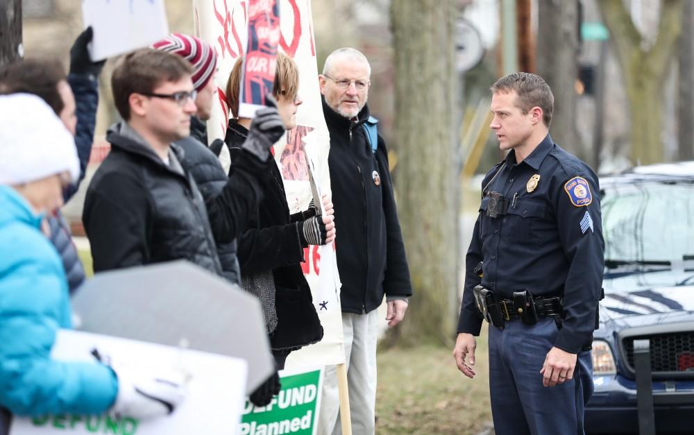 Grand Rapids Police Department's officer Brad Bush controls the crowd in front of the Planned Parenthood building on  425 Cherry St SE in Grand Rapids on Saturday, Feb. 11, 2017. 