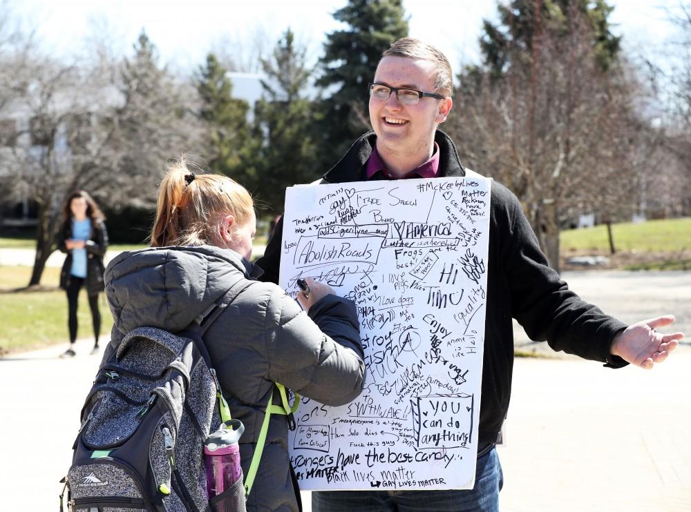 GVL/Kevin Sielaff - A Grand Valley student writes on Nathan Williamsons free speech board on Wednesday, Mar. 22, 2017 outside of Zumberge Hall on Grand Valleys Allendale campus.  
