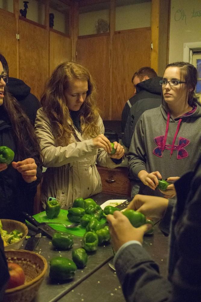 GVL/Mackenzie Bush - Mikayla Mason (left) and Skylar Swifink (right) cut and clean the seeds out of fresh green peppers at the Sustainable Agriculture Project Monday, Oct. 24, 2016 during the Fresh From the Garden event. 