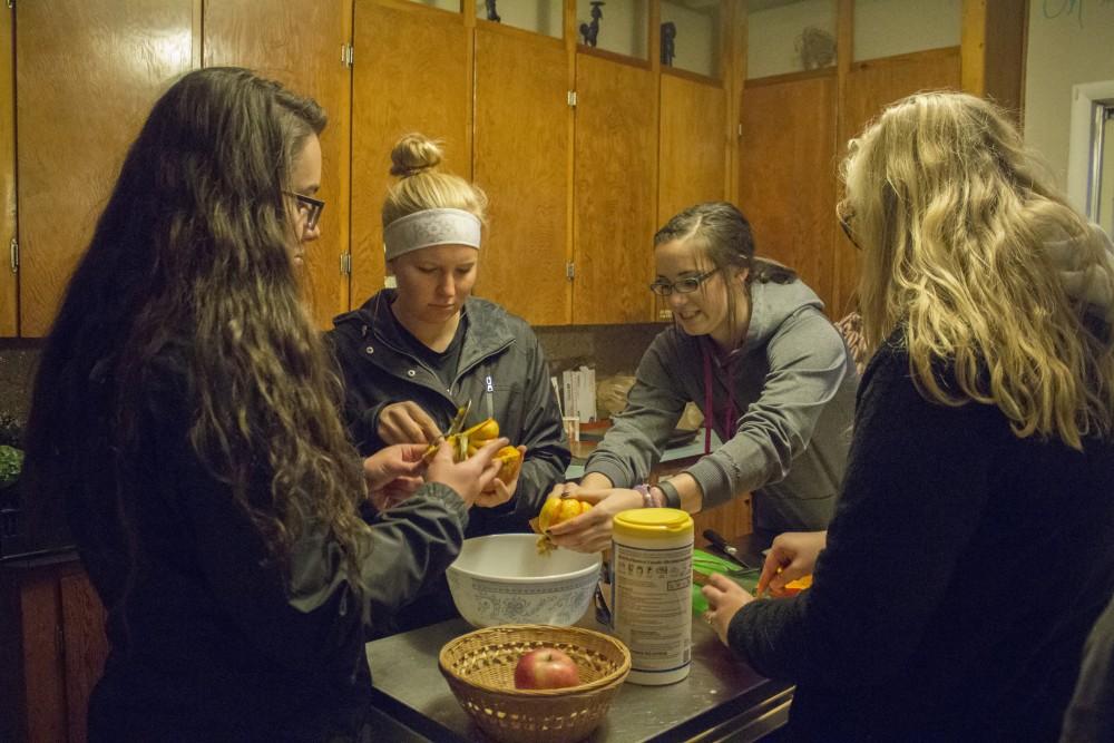 GVL/Mackenzie Bush - Emily Smith (left), Lexi Henckel (middle), Skylar Swifink (right) and Maddie Buning (far right) cut and prepare winter squash at the Sustainable Agriculture Project Monday, Oct. 24, 2016 during the Fresh From the Garden event. 