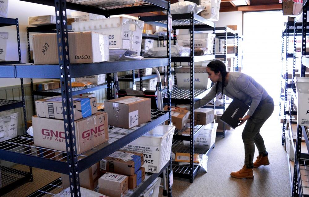 GVL/ Hannah Zajac- Freshman Mya Adame sorts through packages in the Ravines Center mail room on Wednesday, Mar. 22, 2017​.