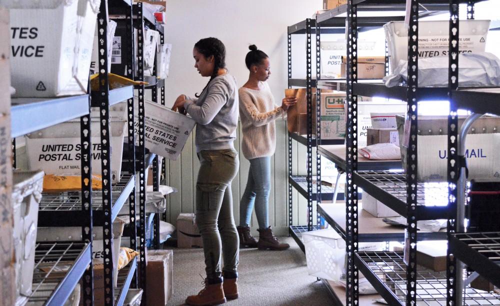 GVL/ Hannah Zajac- Freshman Mya Adame (left) and senior Morgan Harris-Fielder (right) sorts through packages in the Ravines Center mail room on Wednesday, Mar. 22, 2017​.