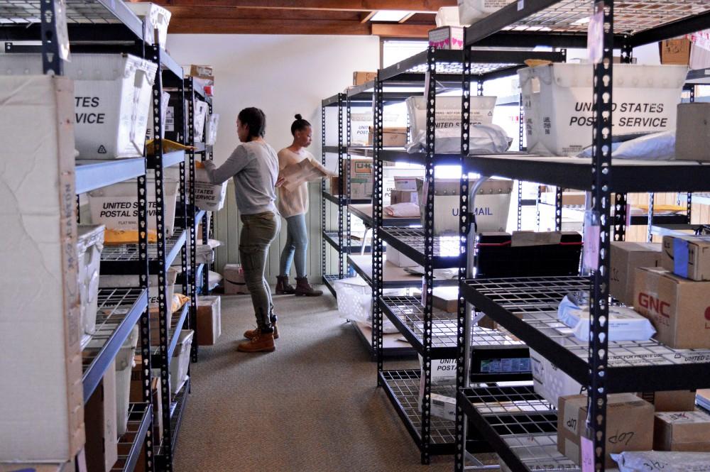 GVL/ Hannah Zajac- Freshman Mya Adame (left) and senior Morgan Harris-Fielder (right) sorts through packages in the Ravines Center mail room on Wednesday, Mar. 22, 2017​.