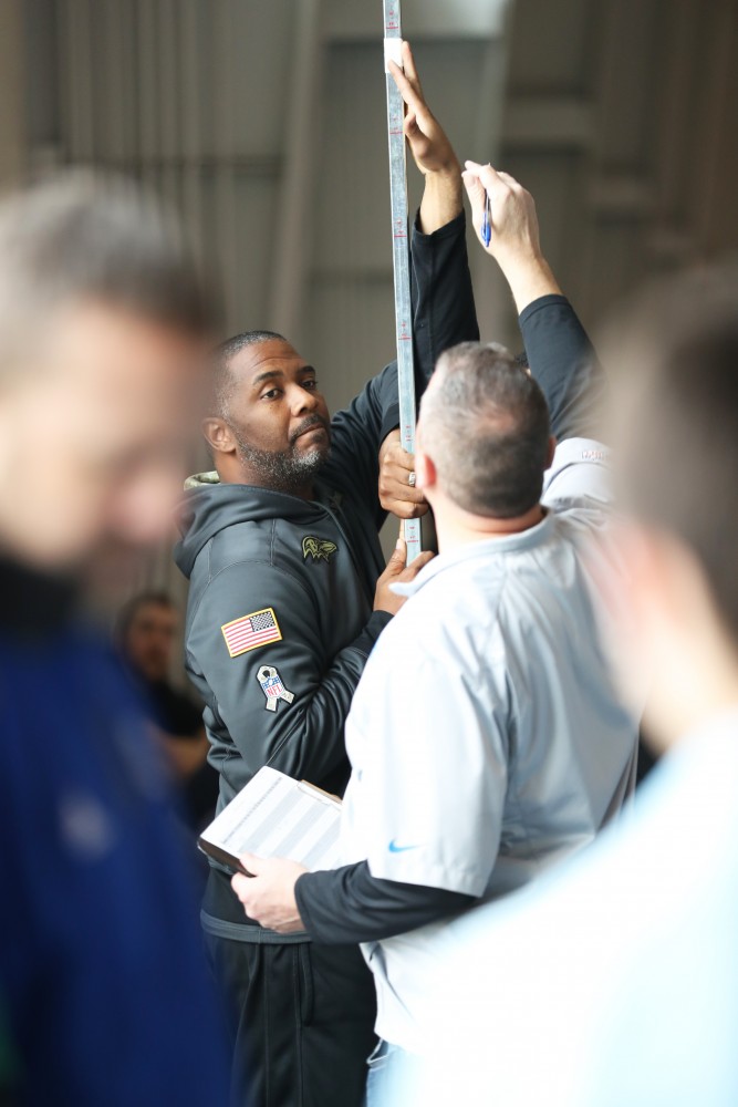 GVL/Kevin Sielaff - NFL scouts set up the vertical jump bar during Pro Day inside the Kelly Family Sports Center on Monday, Mar. 20, 2017.