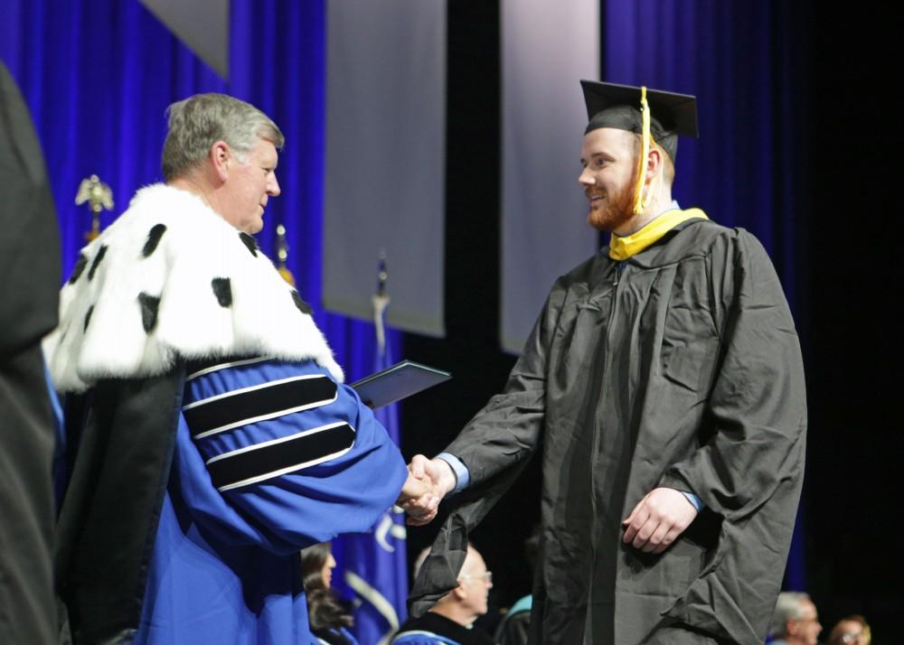 GVL / Emily FryeGrand Valley State Univeristy student Kevin Meyer celebrates receives his masters diploma during graduation on Saturday April 29, 2017.