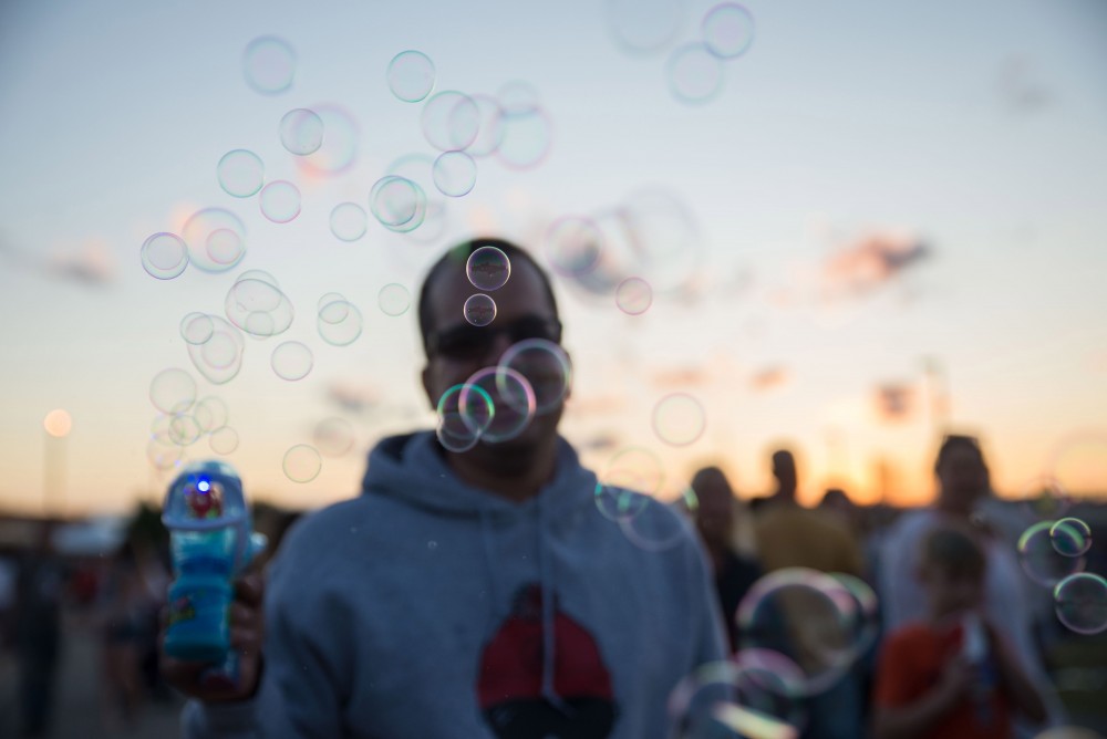 GVL / Luke Holmes - A man fires bubbles from his bubble-gun. The Michigan Challenge Balloonfest was held in Howell, MI on Saturday, June 24, 2017.