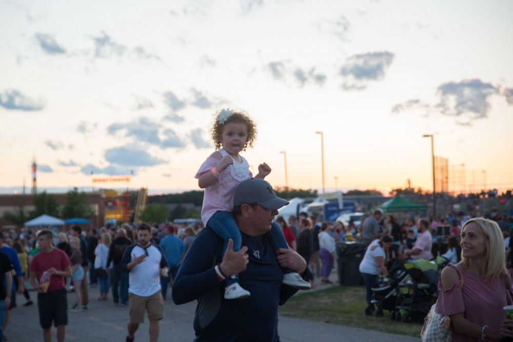 GVL / Luke Holmes - A father carries his daughter on his shoulders. The Michigan Challenge Balloonfest was held in Howell, MI on Saturday, June 24, 2017.