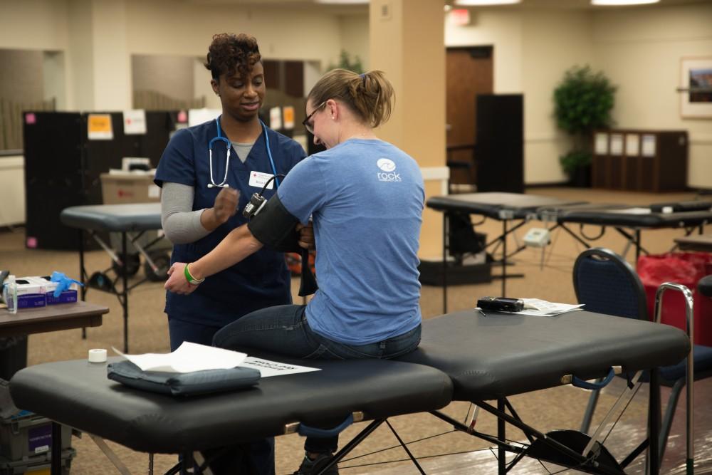 GVL / Luke Holmes - Erica helps get a student ready to draw blood. The blood drive was held by the American Red Cross in the Grand River Room Wednesday, Mar. 30, 2016
