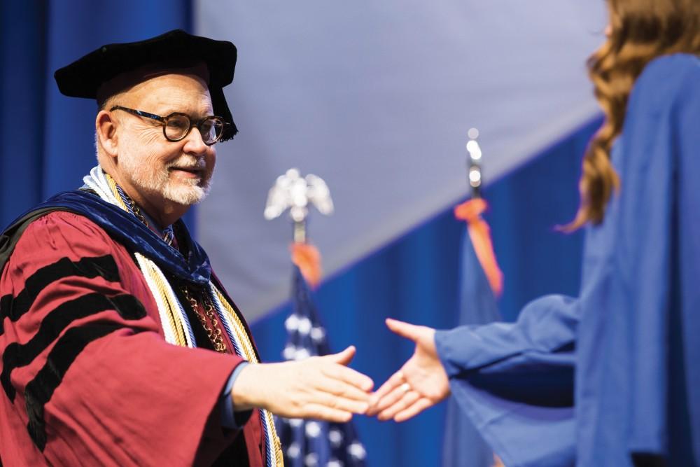 GVL/Archive Dean of the college of liberal arts and sciences, Frederick J. Antczak, shakes hands with students as they walk across the stage to recieve their diploma and graduate at the 2015 commencement ceremony, Saturday April 25.