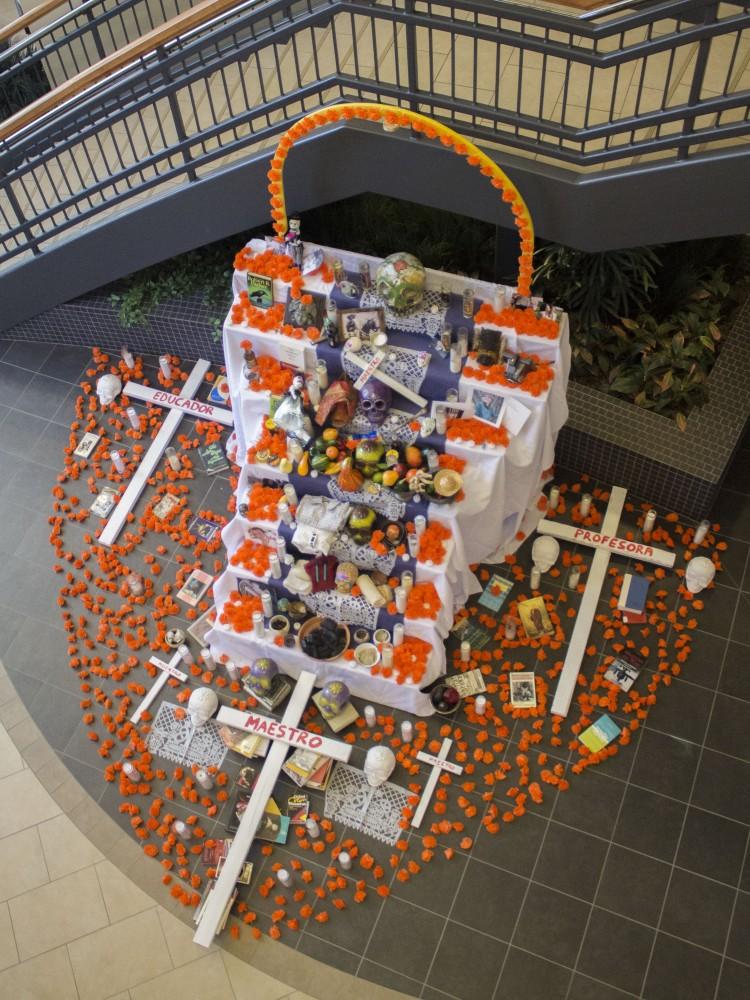 GVL/Mackenzie Bush - GVSU students celebrate Day of the Dead with LAS, Latin American, and Latino Studies by placing pictures of loved ones on an alter. The alter, built by artist Roli Mancera, was set up in Neimeyer the week of Nov. 1, 2016.