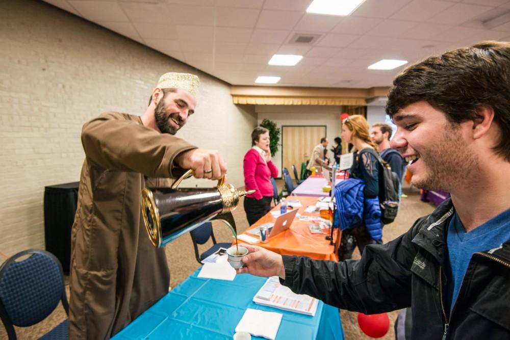 GVL / Courtesy - Alissa LaneProfessor Sebastian Maisel of the Oman/United Arab Emirates serves tea to students at the Study Abroad Fair wearing a traditional outfit (2015).